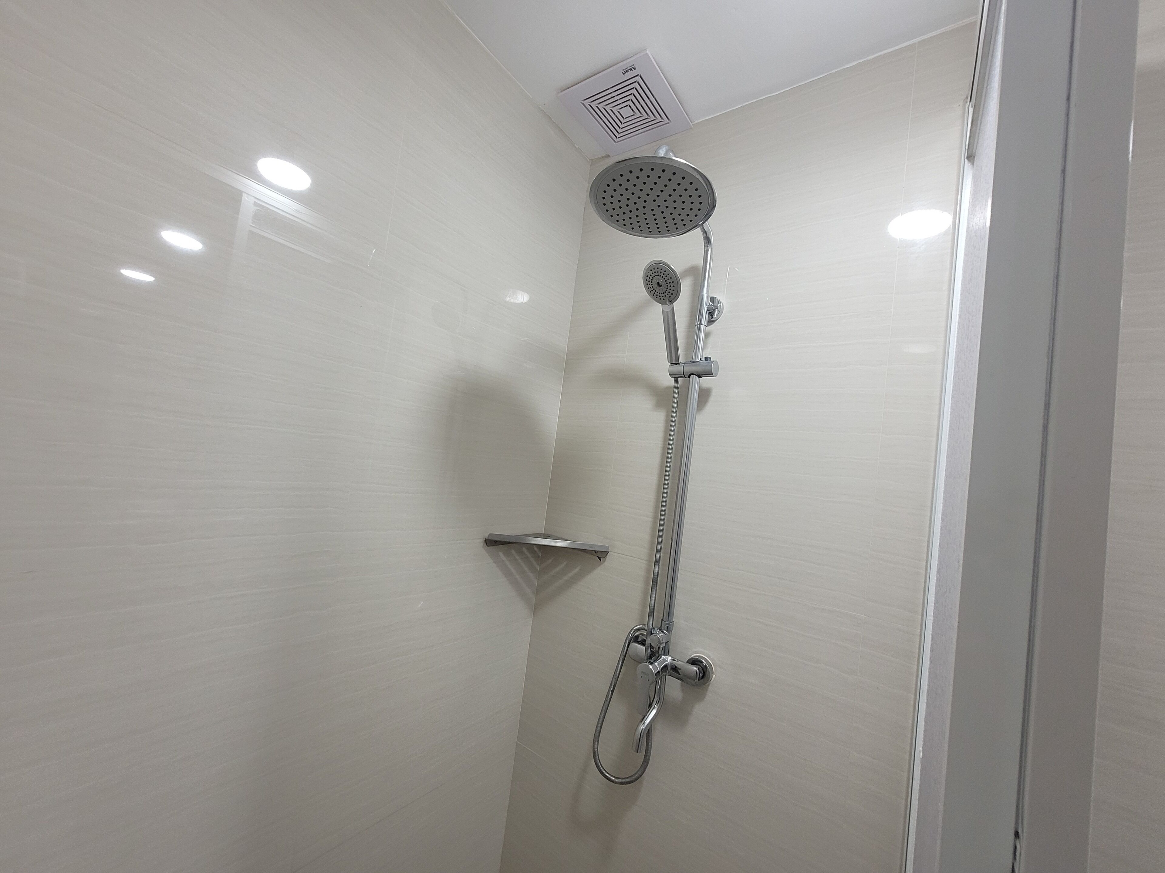 Eine moderne Dusche mit Handbrause und Duschkopf für Regenmassage.