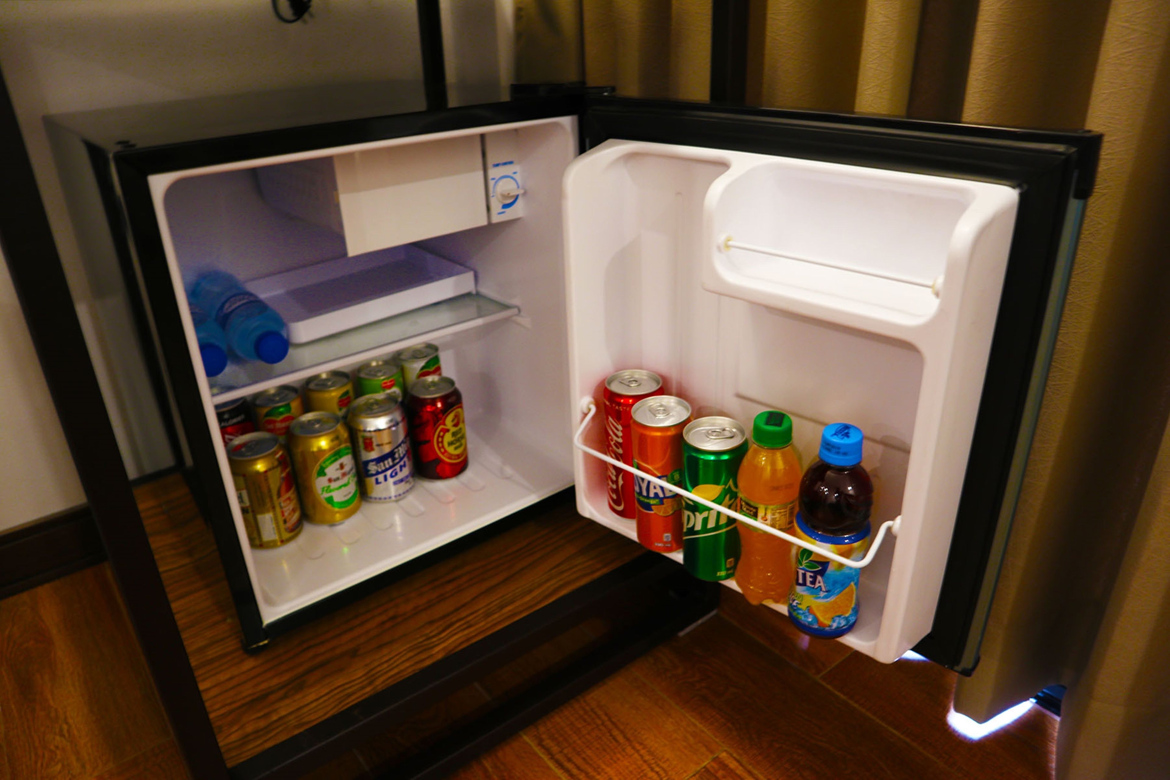 Un réfrigérateur ouvert contenant diverses boissons et des canettes.