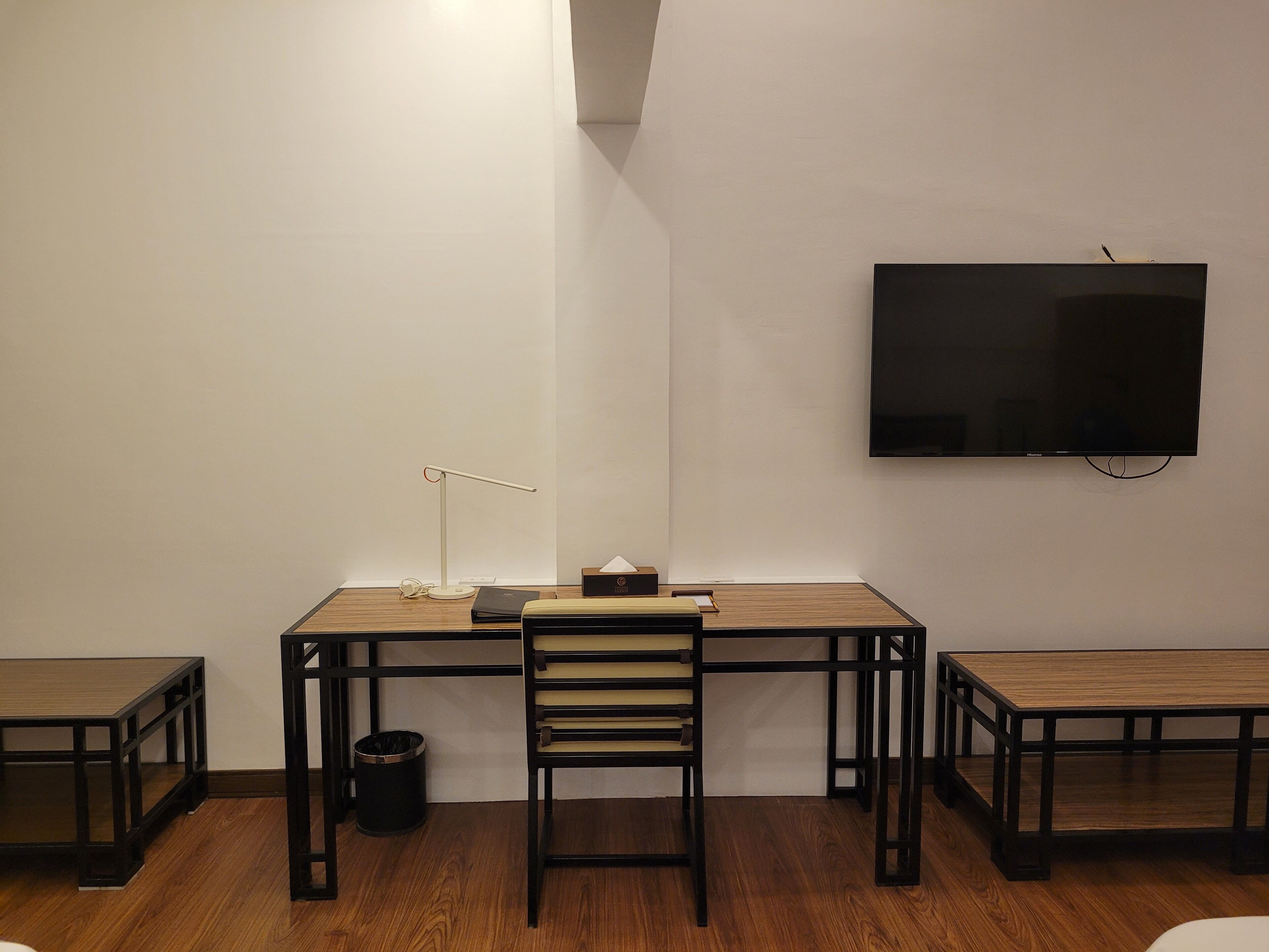 Une pièce comprenant un bureau, une chaise et deux petites tables.