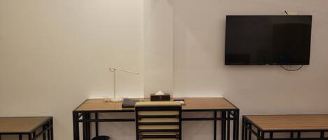 Une pièce comprenant un bureau, une chaise et deux petites tables.