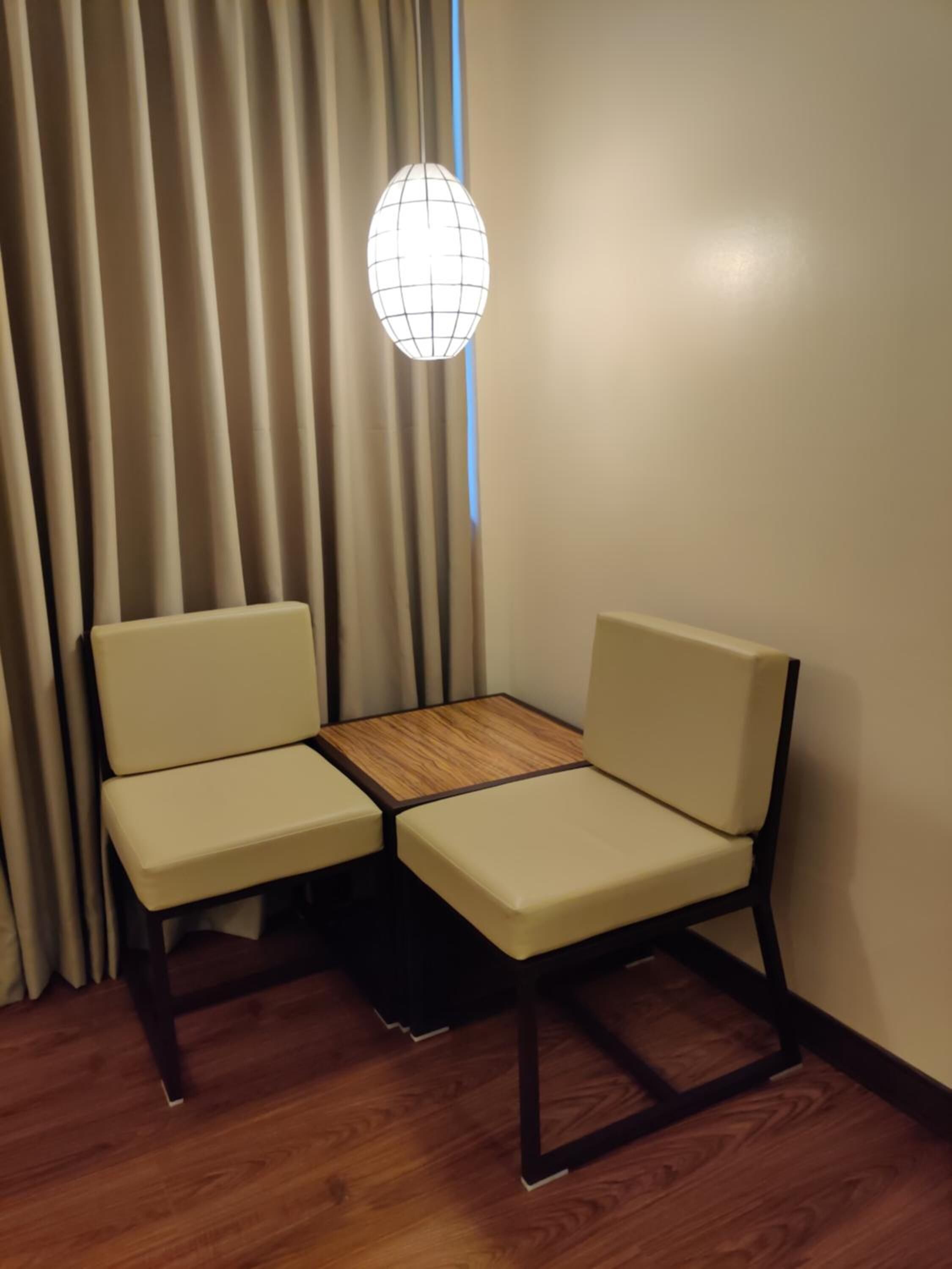 A small room with two beige chairs and a wooden table.