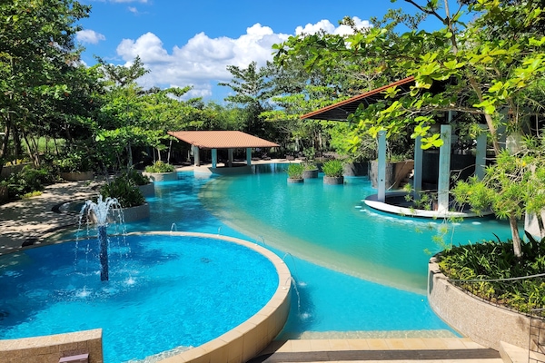 Una piscina al aire libre, sillones reclinables de piscina