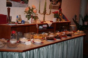 A buffet table with various food items and a candelabra. - Hotel Sonnenhof (Bad Wildbad)