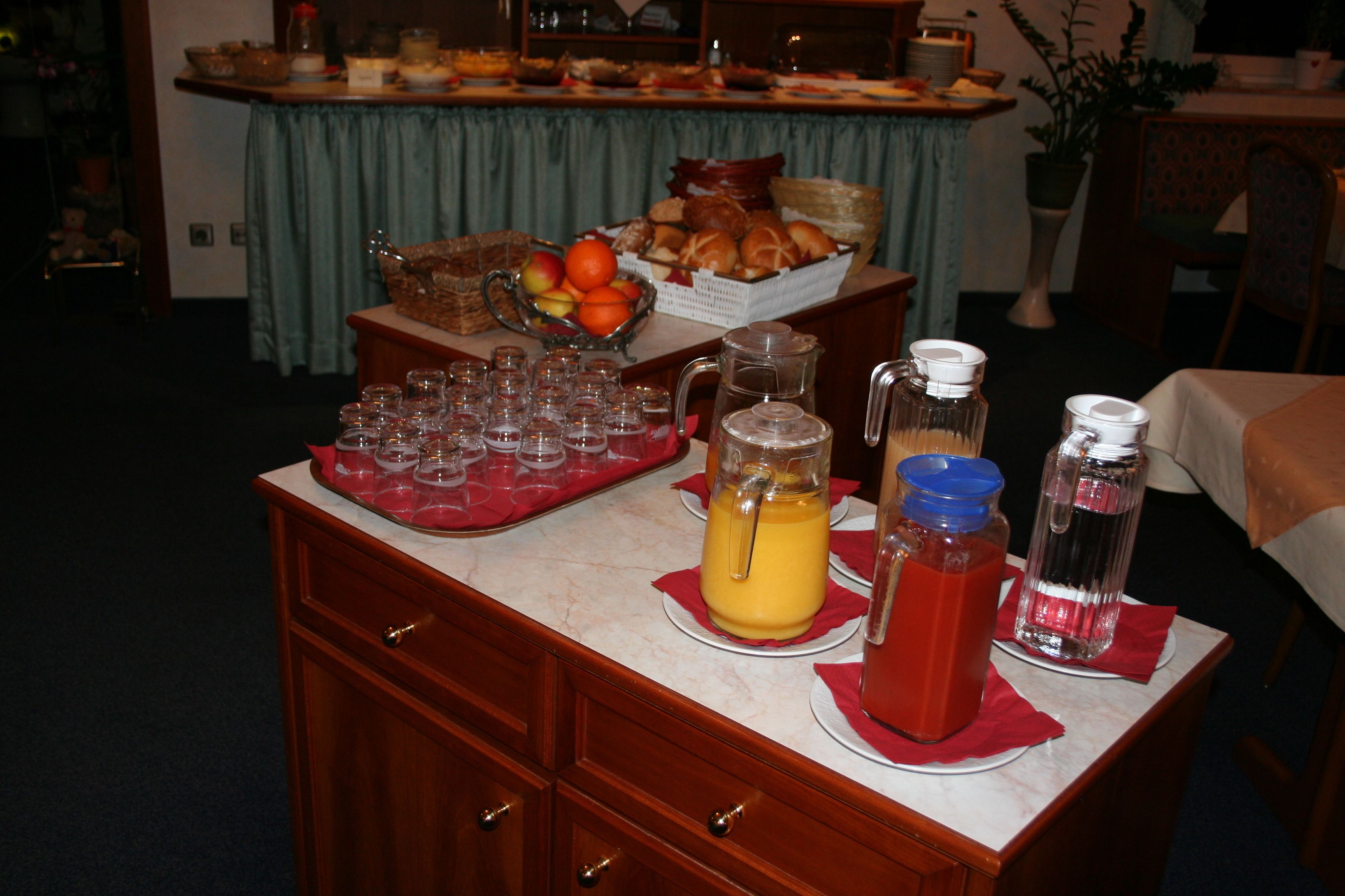 Disposição de buffet com diversos alimentos e bebidas sobre um balcão de mármore.