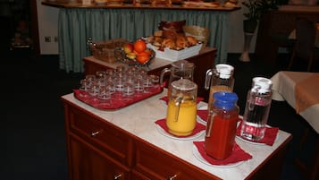 Disposição de buffet com diversos alimentos e bebidas sobre um balcão de mármore.