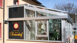 A hotel with a modern design, featuring large windows and a balcony. - Hotel Sonnenhof (Bad Wildbad)