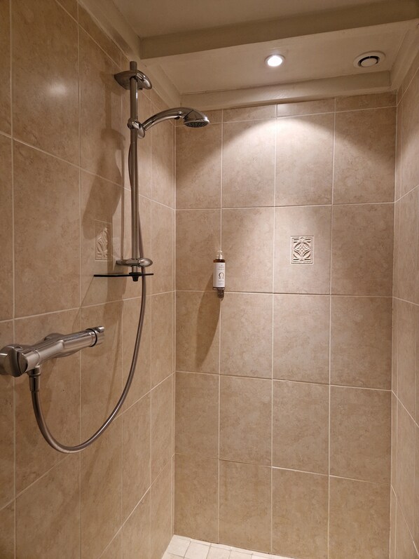 A shower with a handheld showerhead, a wall-mounted faucet, and a handheld shower hose. - Hotel Mas de Fauchon (Saint-Cannat)