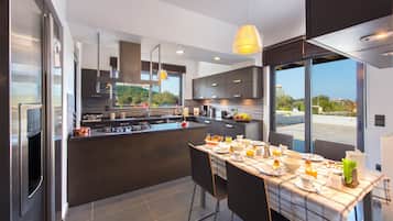 Vila família, 4 quartos, piscina particular | Cozinha privada | Geladeira, micro-ondas, fogão, cooktop