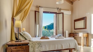 Un dormitorio con cama, mesitas de noche, un espejo y vistas al exterior.