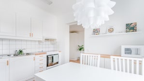 Una cocina moderna con muebles blancos, una isla central y un microondas en la encimera.