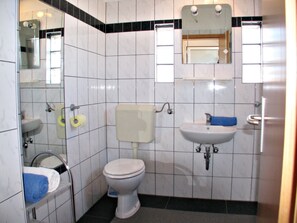 A small bathroom with a toilet, sink, and mirror. - Apartments Galic (Nin)