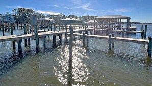 A pier with wooden walkways and covered structures, extending into calm water. - Come get your toes in the sand! Enjoy the Vitamin Sea ☀️ (Orange Beach)