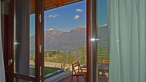 Varanda com vista para montanhas e um lago.