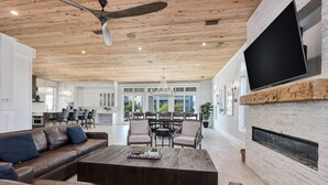 A spacious living room with a wooden ceiling, leather sofas, a coffee table, and a fireplace. - Paradise at Park Row|Easy Beach Access|Large Resort Style Private Pool (Destin)