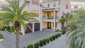 A two-story house with a balcony, a garage, and a driveway. - Paradise at Park Row|Easy Beach Access|Large Resort Style Private Pool (Destin)