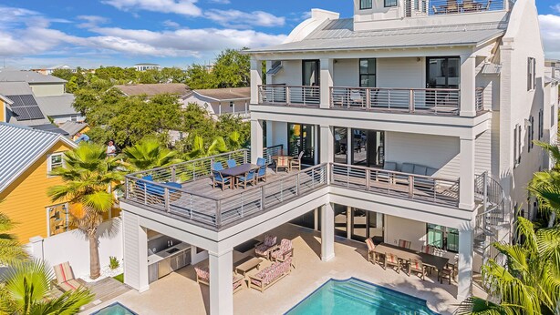 A multi-story resort with a rooftop pool, outdoor seating, and a large swimming pool. - Paradise at Park Row|Easy Beach Access|Large Resort Style Private Pool (Destin)