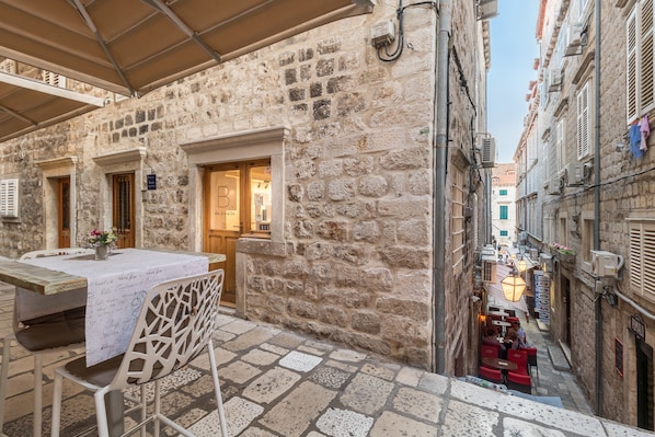 A stone building with a table and chairs set up for outdoor dining.