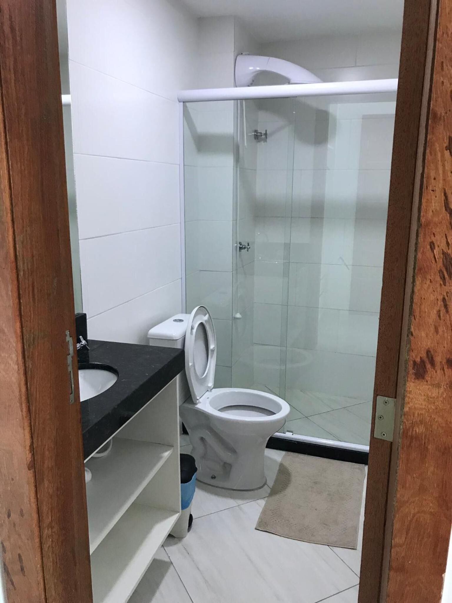 Une salle de bain équipée de toilettes, d’un lavabo et d’une douche à parois en verre.