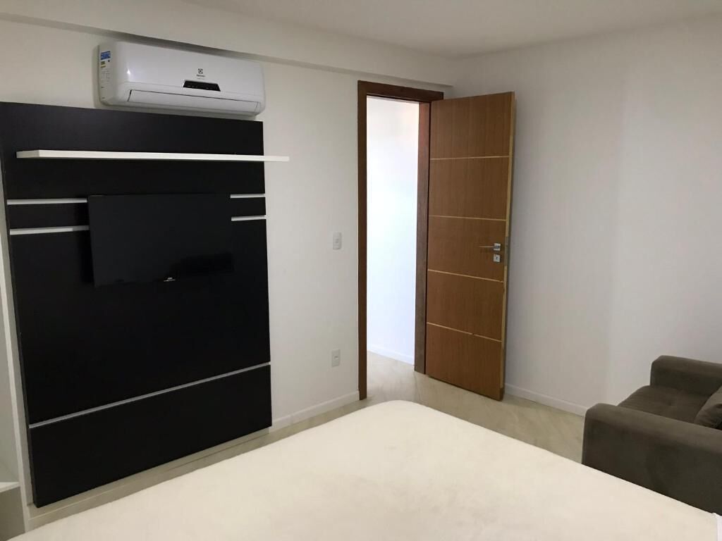 Une pièce comprenant un lit, une armoire, une porte et un petit canapé.