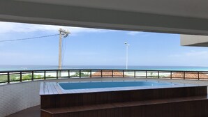 A rooftop pool with a view of the ocean and beach. - Sophia II Residence Inn (Arraial do Cabo)
