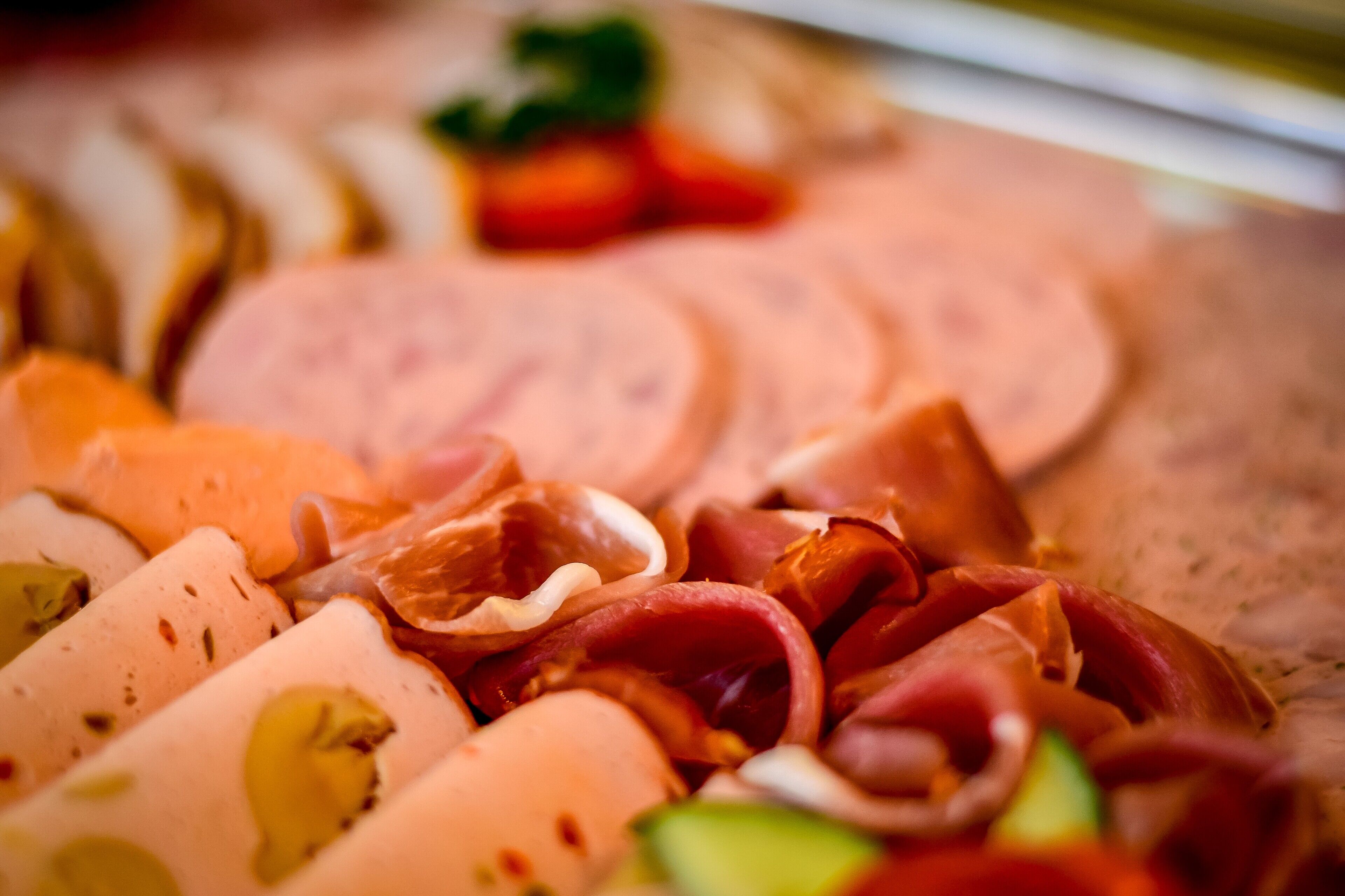 Eine Auswahl an Aufschnitt und Käse auf einem Holzbrett.