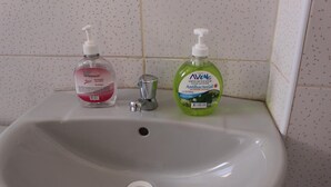Ein Waschbecken mit zwei Handdesinfektionsflaschen.
