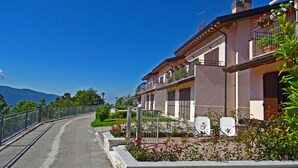 A residential street with houses, a clear sky, and mountains in the background. - La Quiete 29 Holideal (Tremosine)