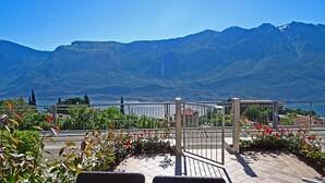 A terrace with a view of a lake and mountains, featuring a railing and potted plants. - La Quiete 29 Holideal (Tremosine)