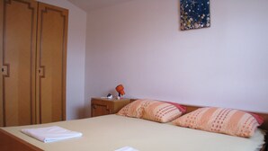 A bedroom with a bed, pillows, a nightstand, and a wall decoration. - Apartment Vitko (Nin)