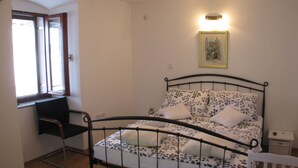 A bedroom with a bed, a desk, and a chair. - Apartment Noa (Kastela)