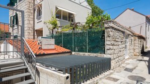 A modern two-story house with a stone facade, a metal fence, and a red-tiled roof. - Split Center Suites (Split)