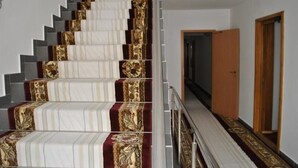 A staircase with patterned carpet runners and a metal handrail. - HOTEL GLOBAL (Bra?ov)