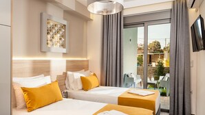 Une chambre d’hôtel avec deux lits, une télévision, un tableau et une vue sur l’extérieur.