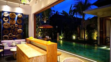 Ein modernes Interieur mit Blick auf einen Pool, einer Holzbank und einer Wand voller Donuts.