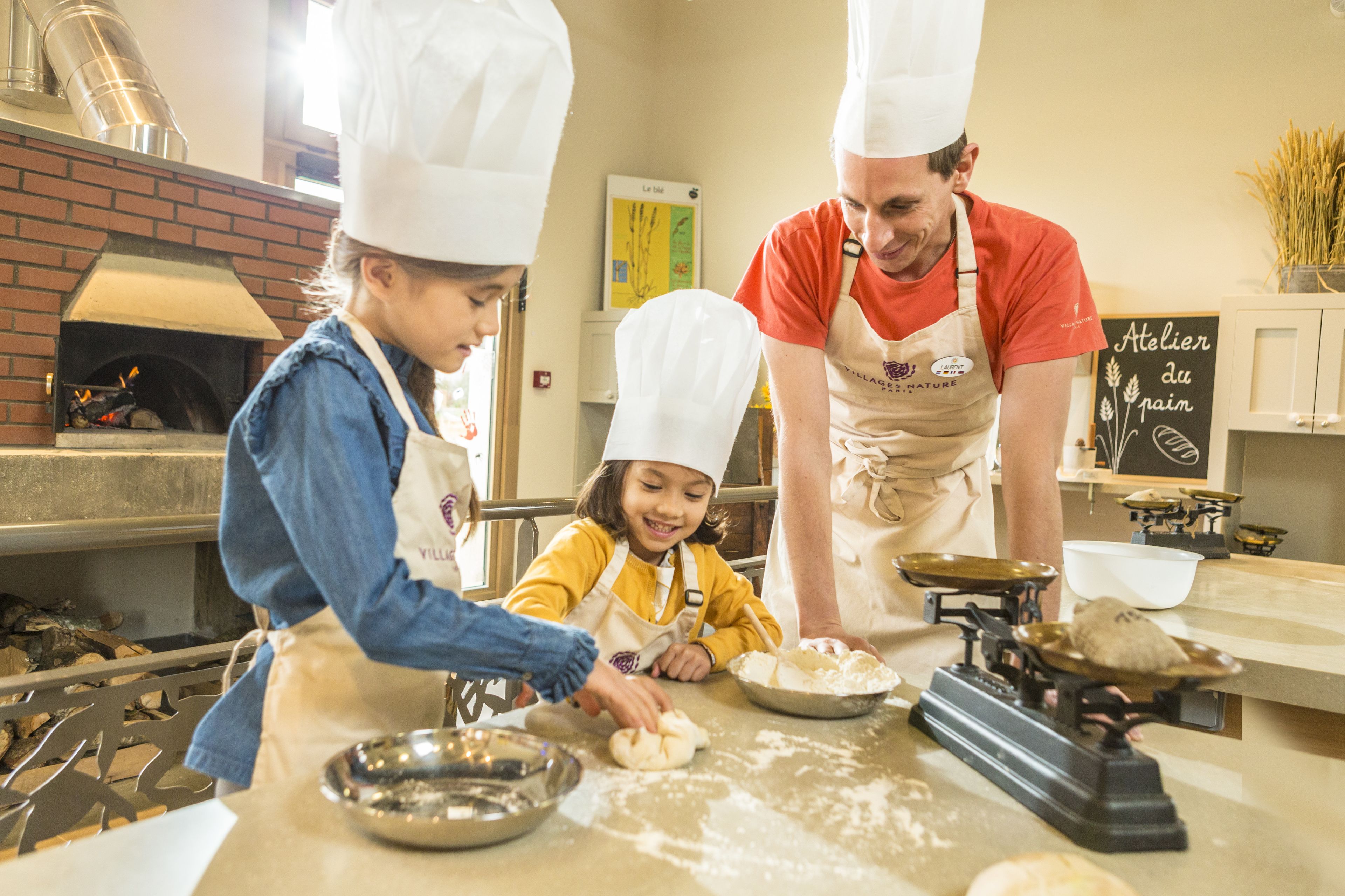 Een keuken met een bakoven, een weegschaal en een schoolbord met tekst erop.
