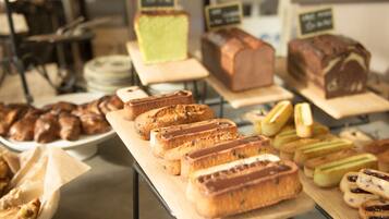 Una vitrina de panadería con distintos tipos de pan y pastelería.
