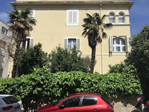 Stunning two-story building with a central entrance and lush green surroundings.