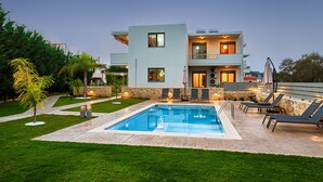 A modern two-story house with a swimming pool, outdoor seating, and a well-maintained garden. - Kagiemar Luxury House (Chania)