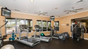 Un gimnasio con cintas de correr, elípticas y pesas libres.