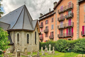 A stone chapel with a pointed roof, surrounded by a cemetery with headstones.