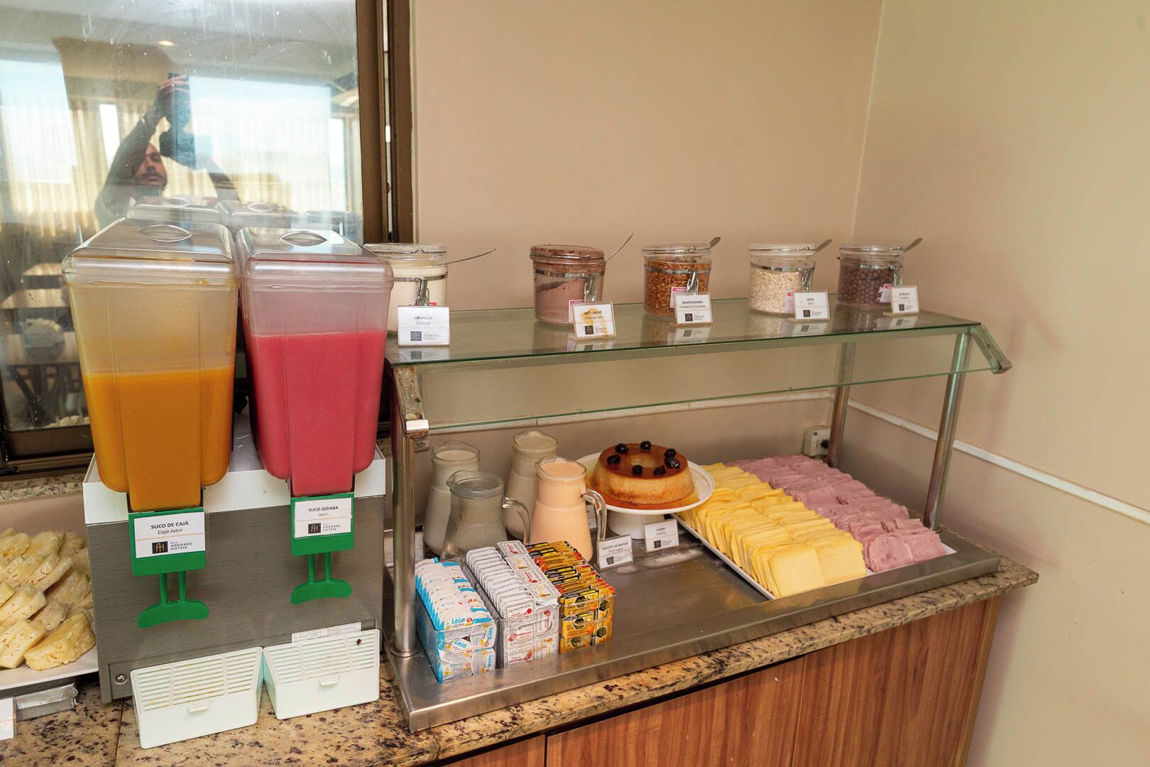 Un bufé de desayuno con varios zumos, batidos y bollería.