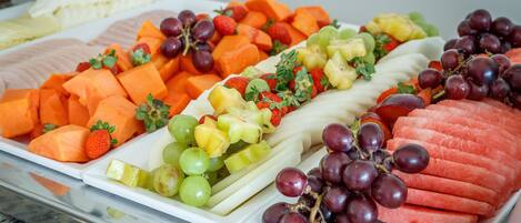 Un assortiment de fruits frais comprenant du raisin, des fraises et de la pastèque.