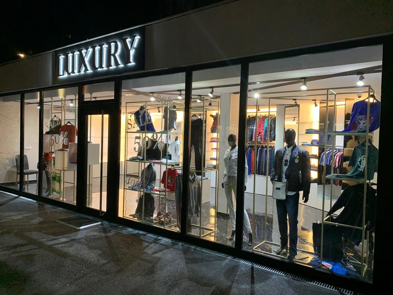 A luxury clothing store with mannequins displaying outfits.