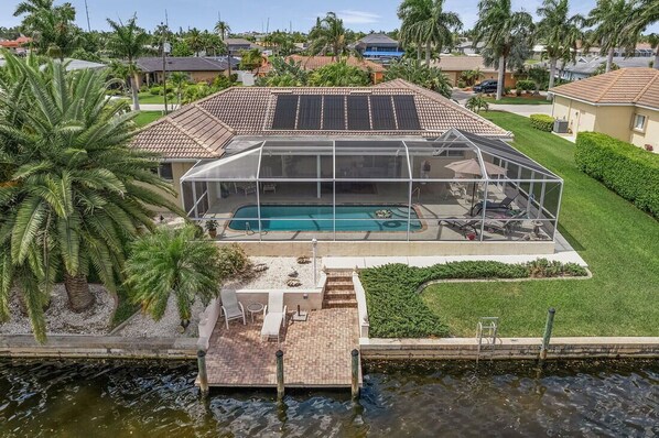 A house with a swimming pool, covered patio, and solar panels. - Location, location, location! Without bridges and locks in the Gulf of Mexico! (Cape Coral)