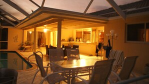 Un patio interno con piscina, tavolo e sedie da pranzo.