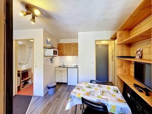 A compact kitchen with a microwave, sink, and wooden cabinets.