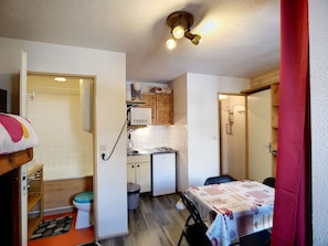 Cozy retreat with a kitchenette, compact sink, toilet, and refrigerator, perfect for a comfortable stay.
