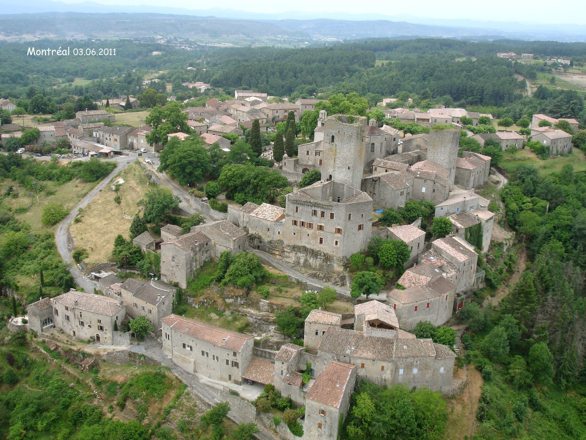 An aerial view of a historic town with medieval architecture, including stone buildings and a castle.