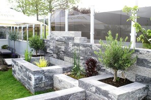 Ein angelegter Garten mit Steinpflanzgefäßen und verschiedenen Sträuchern.