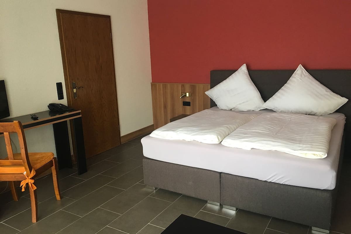 Une chambre à coucher avec un lit, un bureau et une chaise.